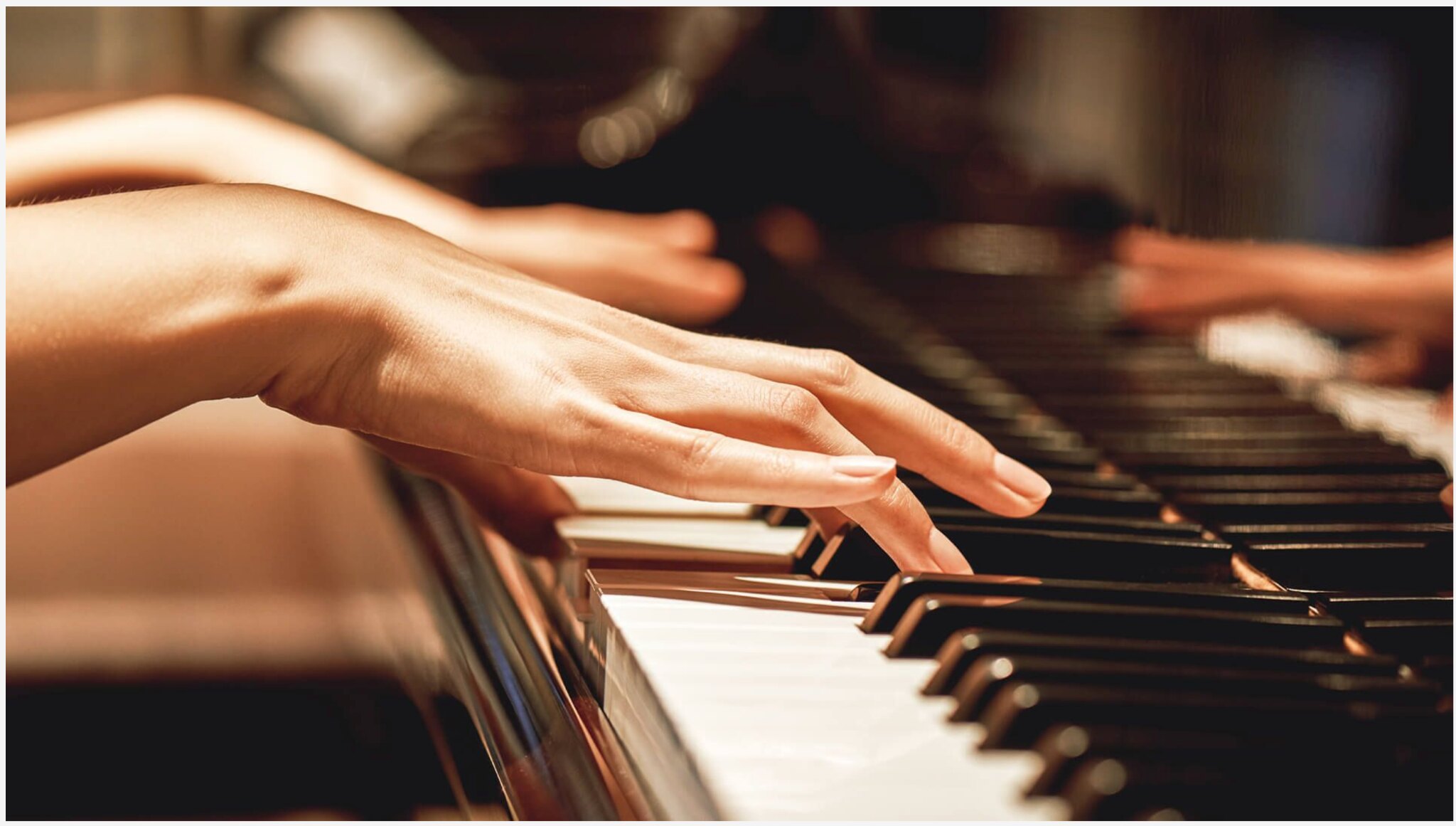Close-up of hands playing piano keys